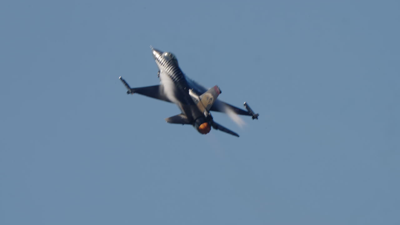 Krachtige F-16 straaljager stijgt op met nabrander in blauwe lucht