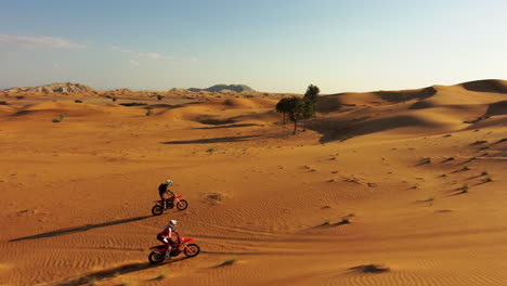 extreme motocross of two rider rides on a dirt track on a sunny summer day. tracking drone shot.