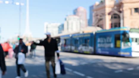 people crossing street near train station