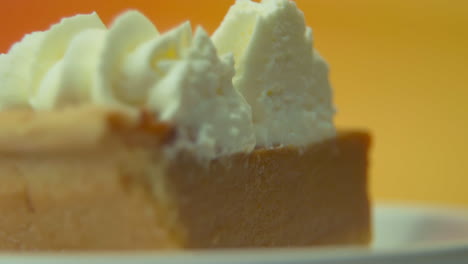 [cámara utilizada: canon c300] toma macro estática, enfoque en el estante, rebanada de pastel de calabaza cargada de crema batida esponjosa