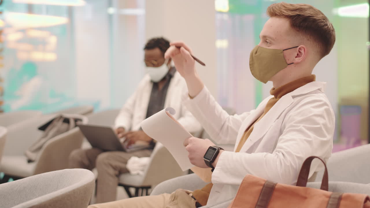 Young Medical Student Raising Hand to Answer at Lecture