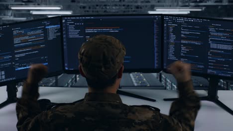 back view of happy asian military celebrating while write code with multiple computer screens in data center