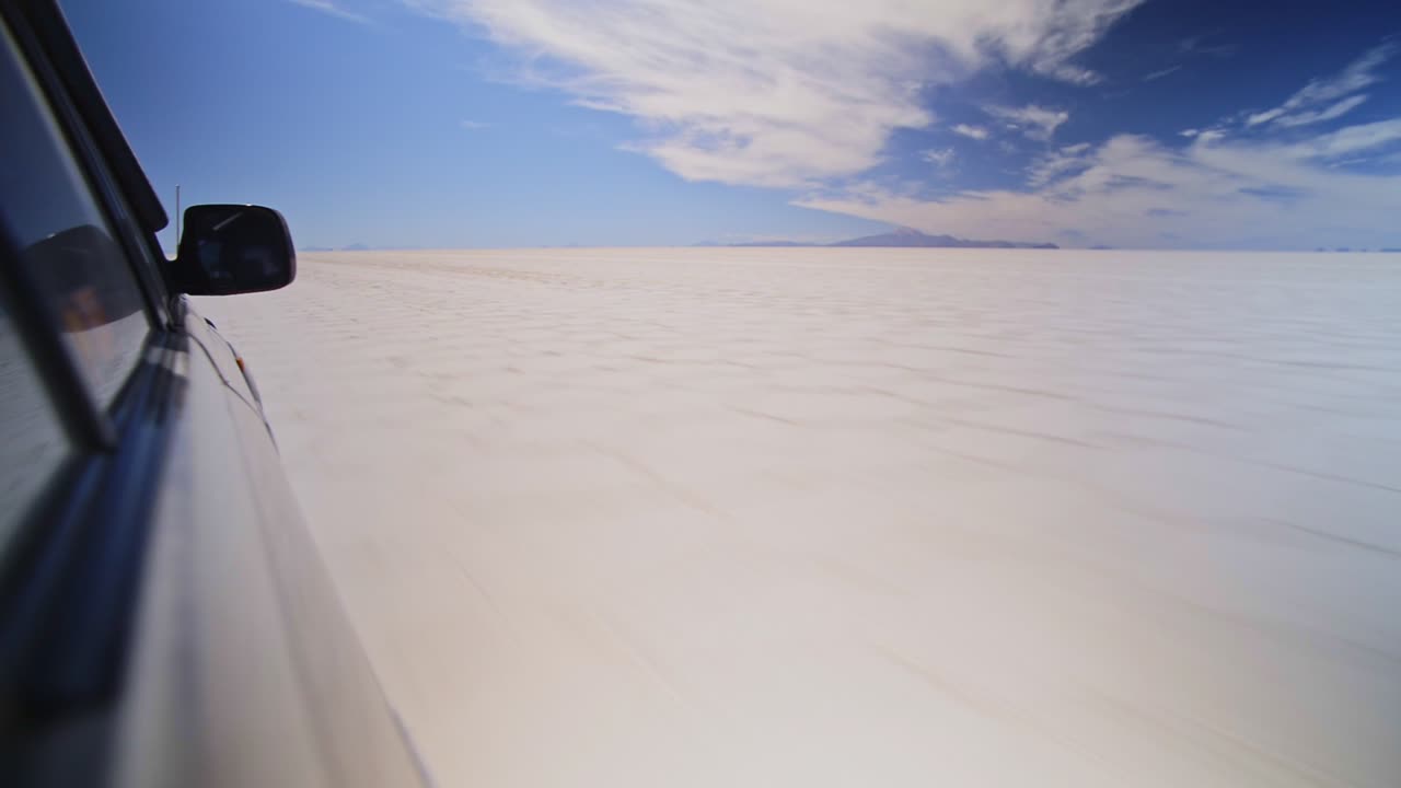 Roadtrip gap year travel adventure driving in a fast speeding car, Salt Flats, Bolivia
