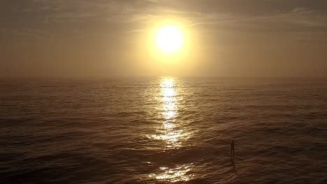 stand up paddle boarder out early with the sunrise