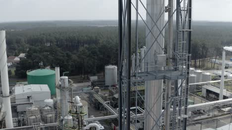 aerial circling shot alongside tall metal lattice tower at industrial drt factory, forest background, veille-saint-girons, france