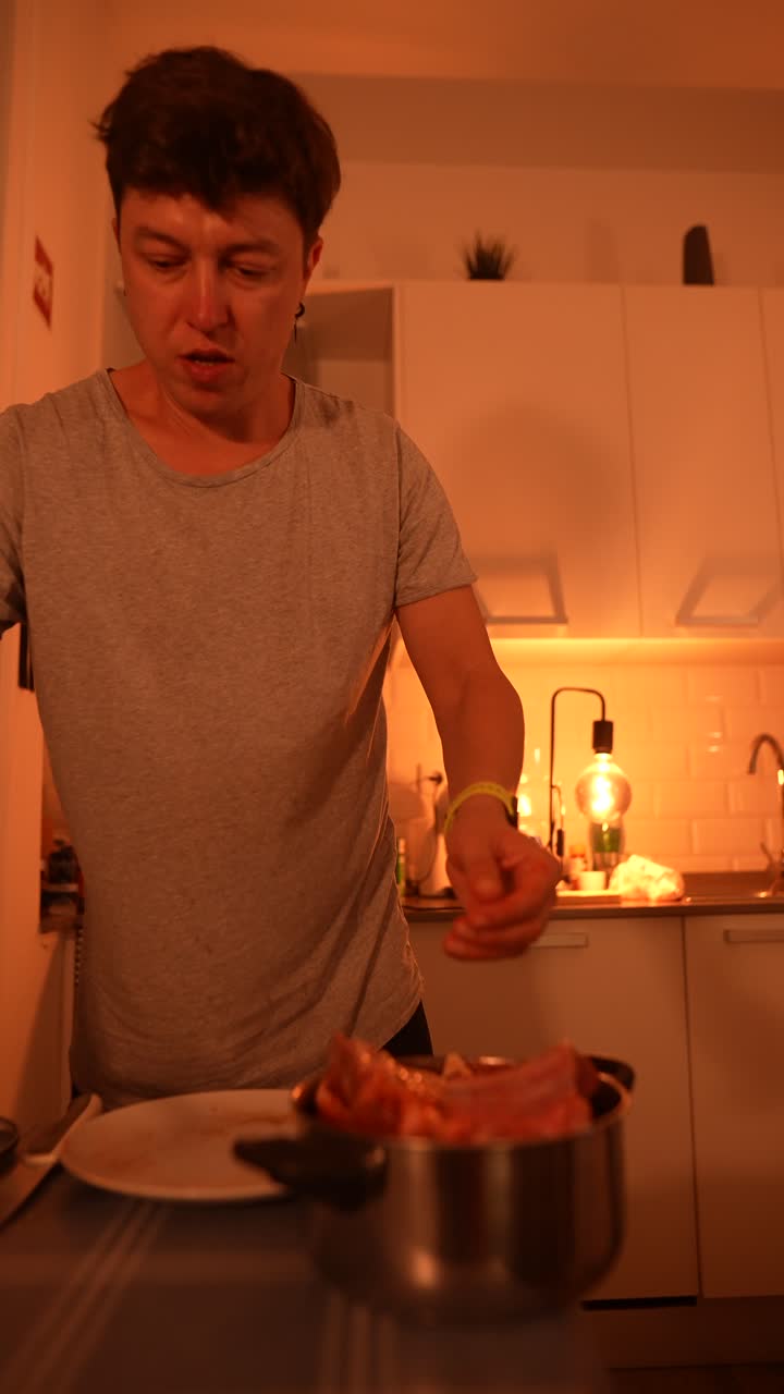 hombre cocinando costillas en casa