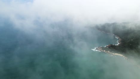 reveal of hainan island coastline, south china sea, dramatic aerial flight in clouds