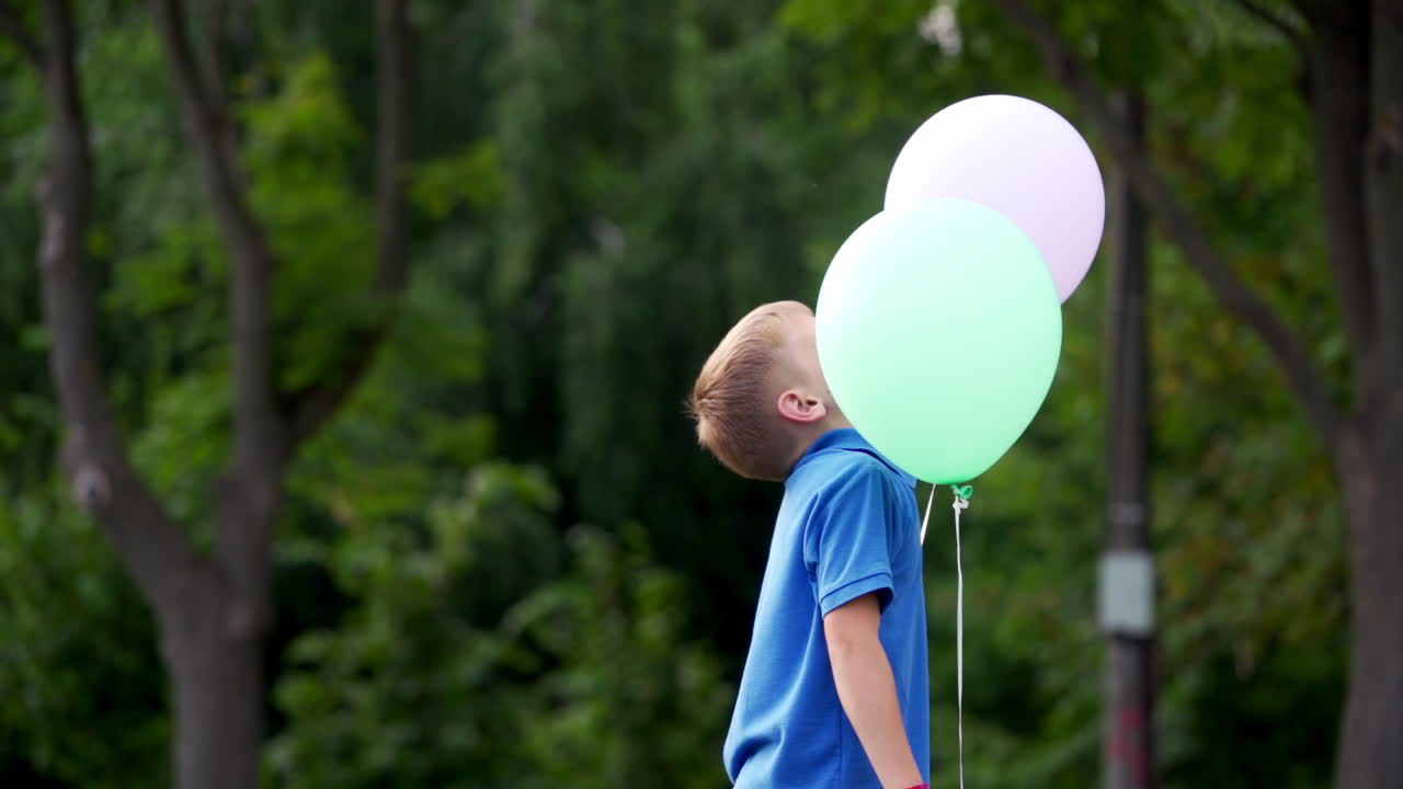 Little boy with balloons. Happy kid having fun with balloons in summer park