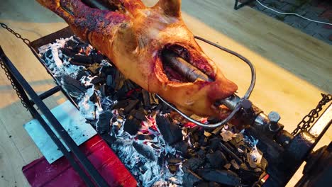 a whole pig cooking on a spit rotisserie barbeque