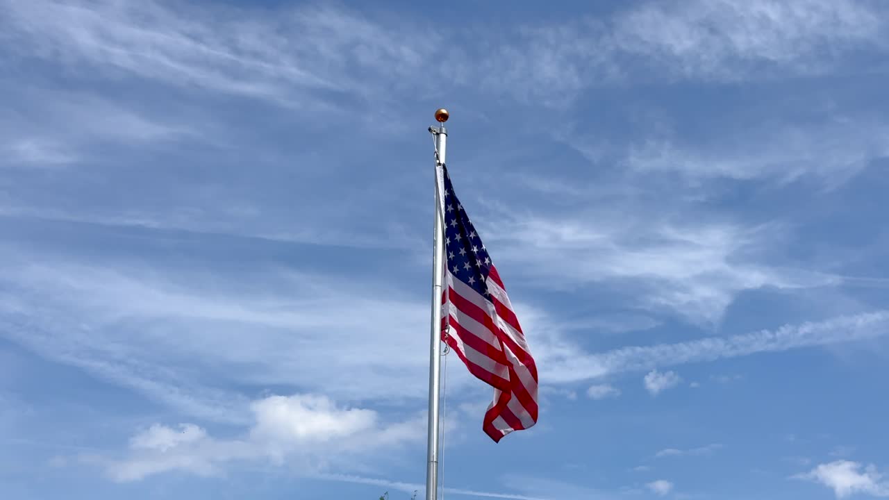 Pride and proud American flag moving in wind. Close up. Patriotic capital towns of fifty states in United States of america. Sunny day with blue sky