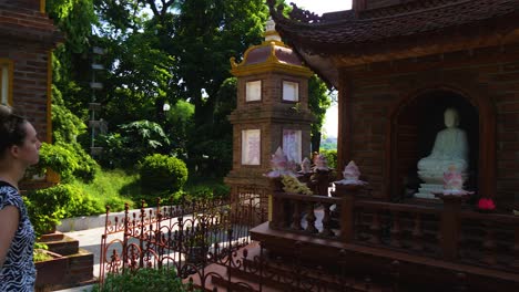 young female tourist takes time to enjoy the beauty of buddhist religious statues