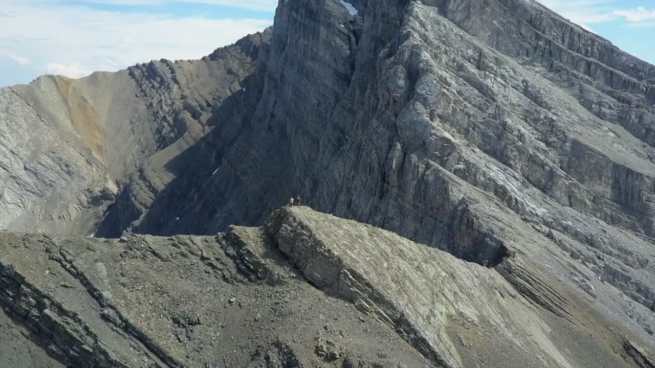 la antena de la cumbre de la montaña orbita a dos escaladores en el pico rocoso alpino