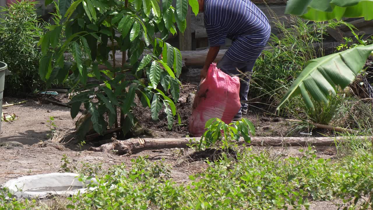 Petani itu berdiri dengan sekop di taman