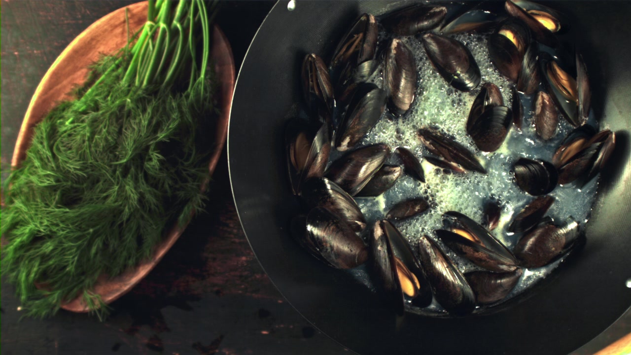Fresh Mussels Opening While Cooking in a Pan Next to Dill