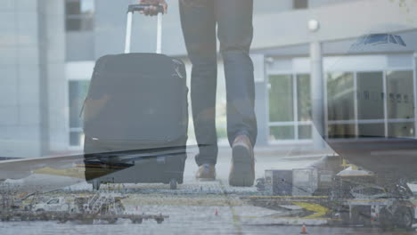 digital composite video of airplane flying against mid section of man with trolley bag walking