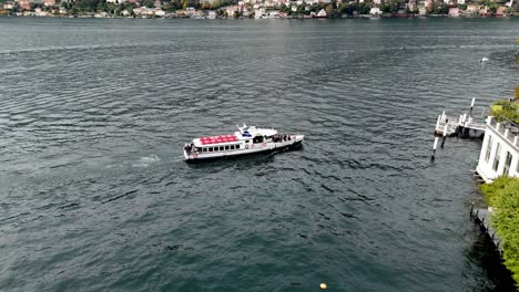 AERIAL---A-Boat-Approach-a-Pier-in-Torno,-Lake-Como