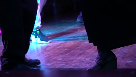 low shot of people learning to dance on a wooden floor.  footsteps going back and forth. dark atmosphere. hd 1080p 59.94p