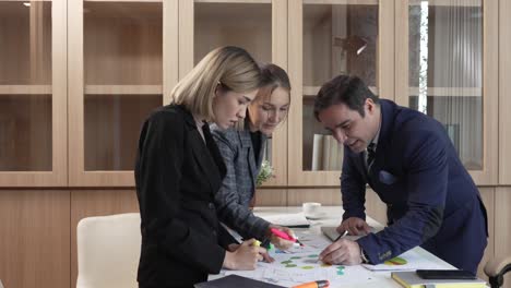 compañeros de trabajo felices hablan discuten ideas de negocio cooperan en el lugar de trabajo de la oficina, personas de negocios de pie apuntando a la discusión de gráficos y estadísticas de papeleo en el escritorio de la oficina.