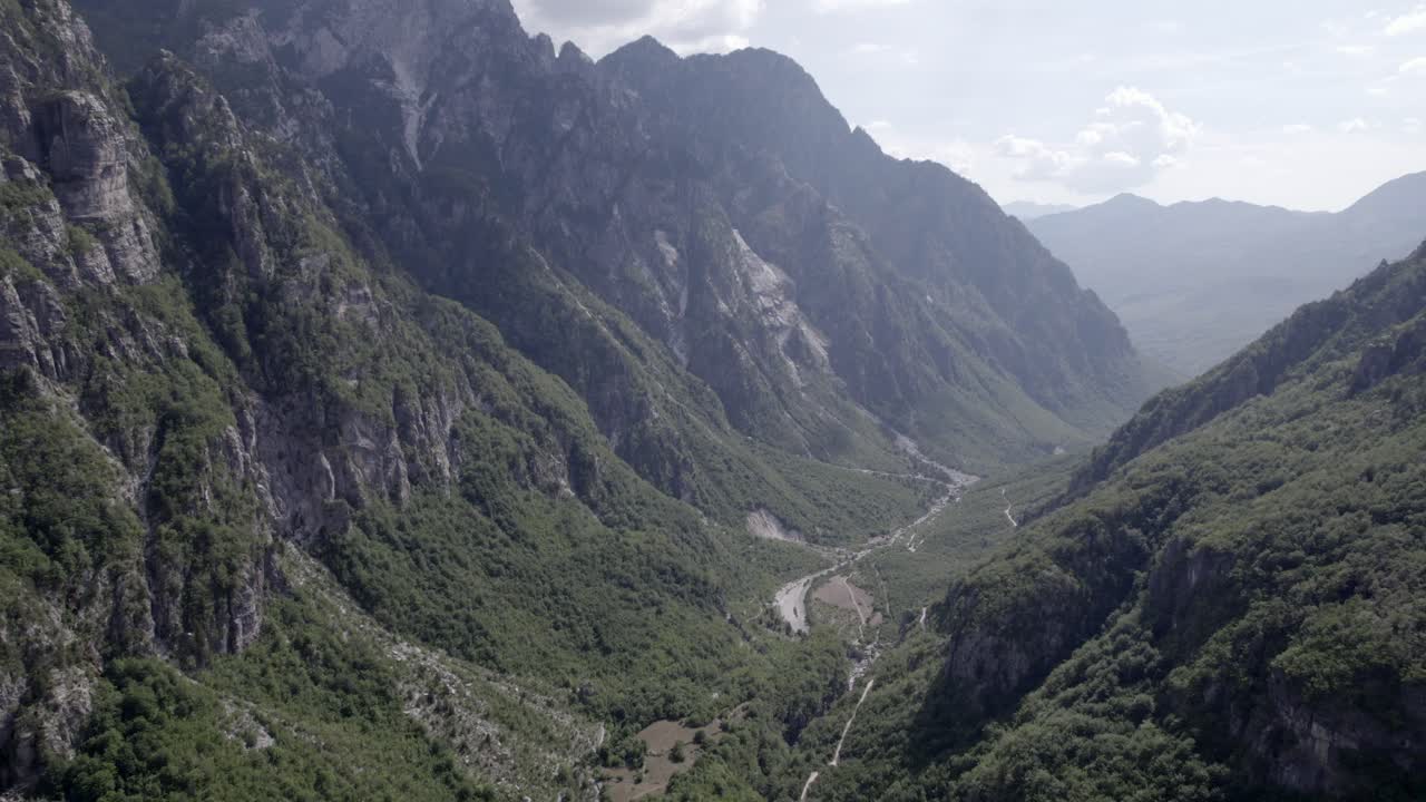 video de dron del avión frontal avanzando dentro del valle theth en albania, en el río lumi i thethit sin apenas agua