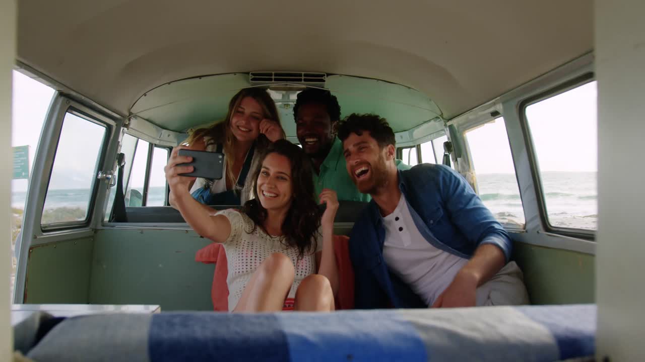 Group of friends taking selfie in camper van 4k