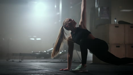 young-slender-woman-is-doing-physical-exercise-on-floor-in-gym-yoga-and-fitness-training