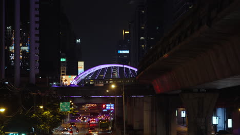 busy elevated bangkok bts skytrain system at night in finance central business district, bangkok night time