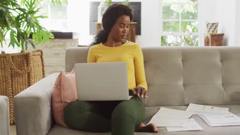 Video-of-happy-african-american-woman-on-sofa-using-laptop