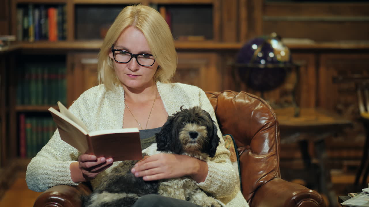 Eine Frau entspannt sich in einer luxuriösen Heimbibliothek und hält einen kleinen Hund.