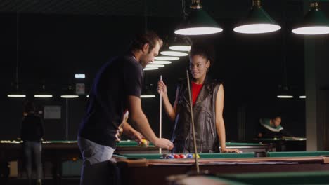 couple playing pool at night