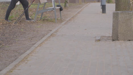 man in long pants stretches at bench in between exercises