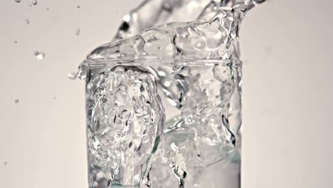 cubitos de hielo cayendo en un vaso de agua