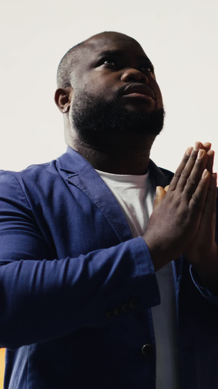 African American Man Praying with Clasped Hands Looking Up