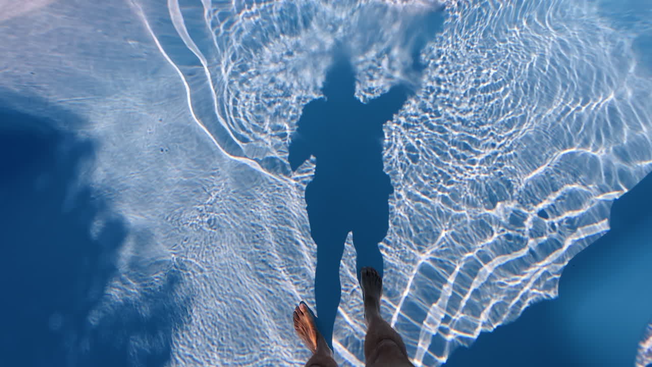 Person's shadow in a swimming pool