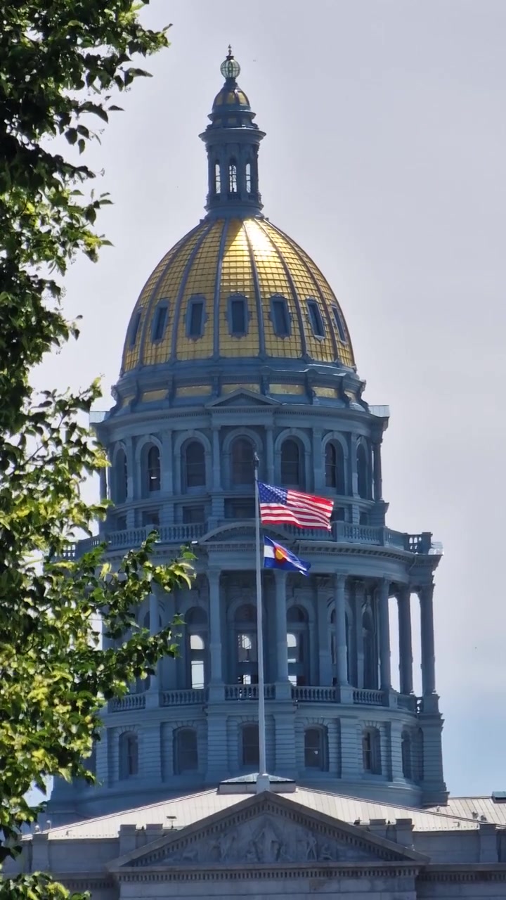 Vista verticale della cupola del Campidoglio dello Stato del Colorado, bandiere americana e statale, Denver, USA