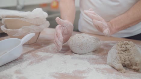 Close-up-shot-of-a-bakery-worker-carefully-shaping-bread