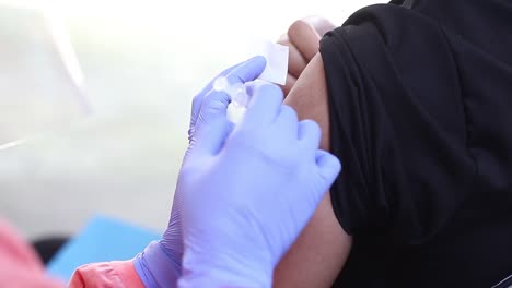 close-up video of a man's arm being injected with the corona virus vaccine