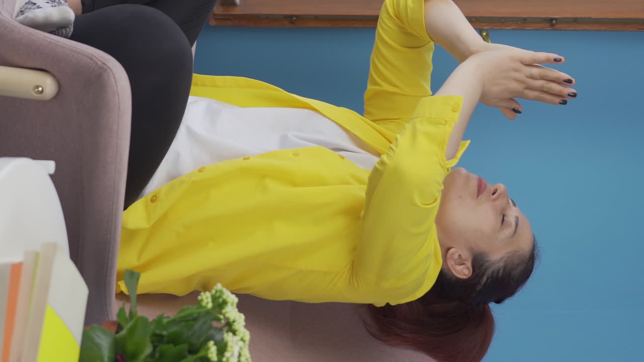 창문 앞에서 명상하는 여성의 수직 비디오.