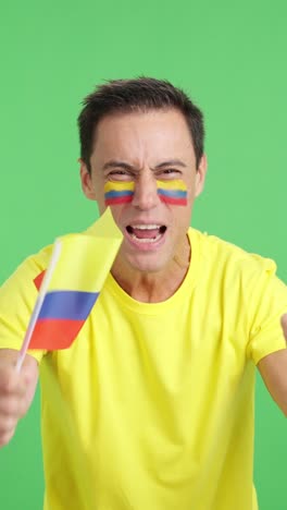man cheering for colombia screaming and waving a national flag