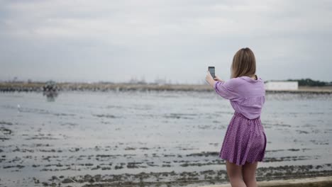 woman taking selfie by the lake
