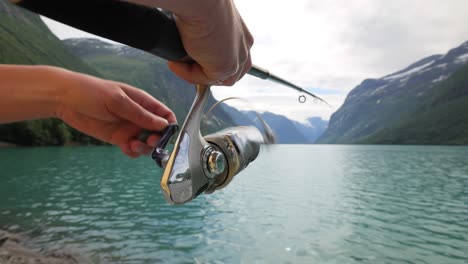 mujer pescando en una caña de pescar girando en noruega.