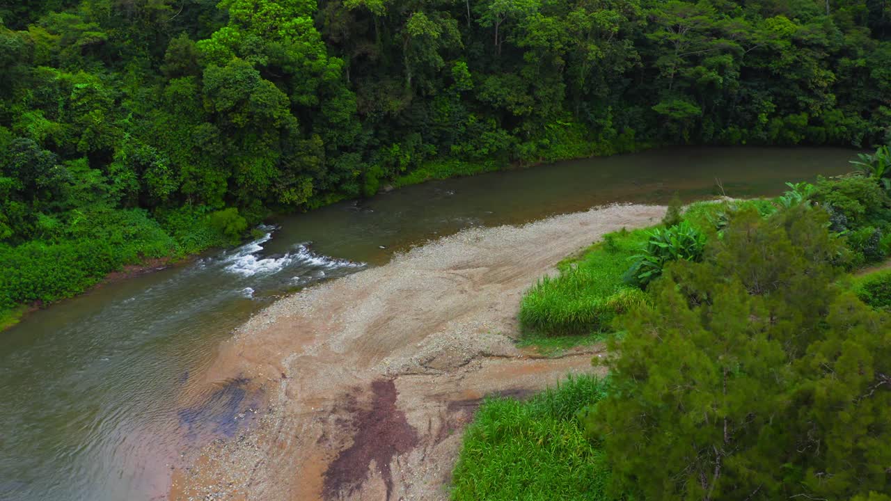 el dron se desliza sobre el serpenteante río tropical, trazando su sinuoso camino a través de una exuberante vegetación