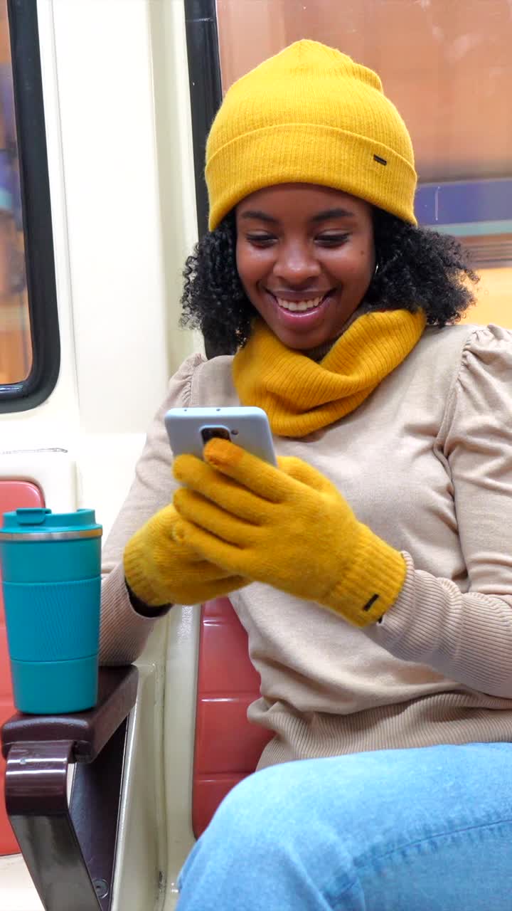 Woman on a subway train using her cell phone