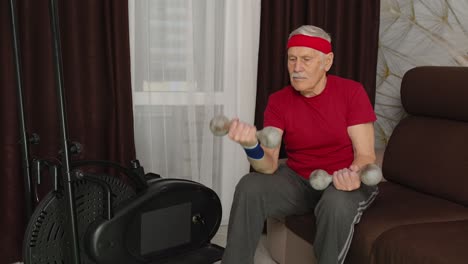 Älterer-Großvater-Macht-Gewichtheben-Hanteln-Training-Und-Aufwärmübungen-Im-Zimmer-Zu-Hause