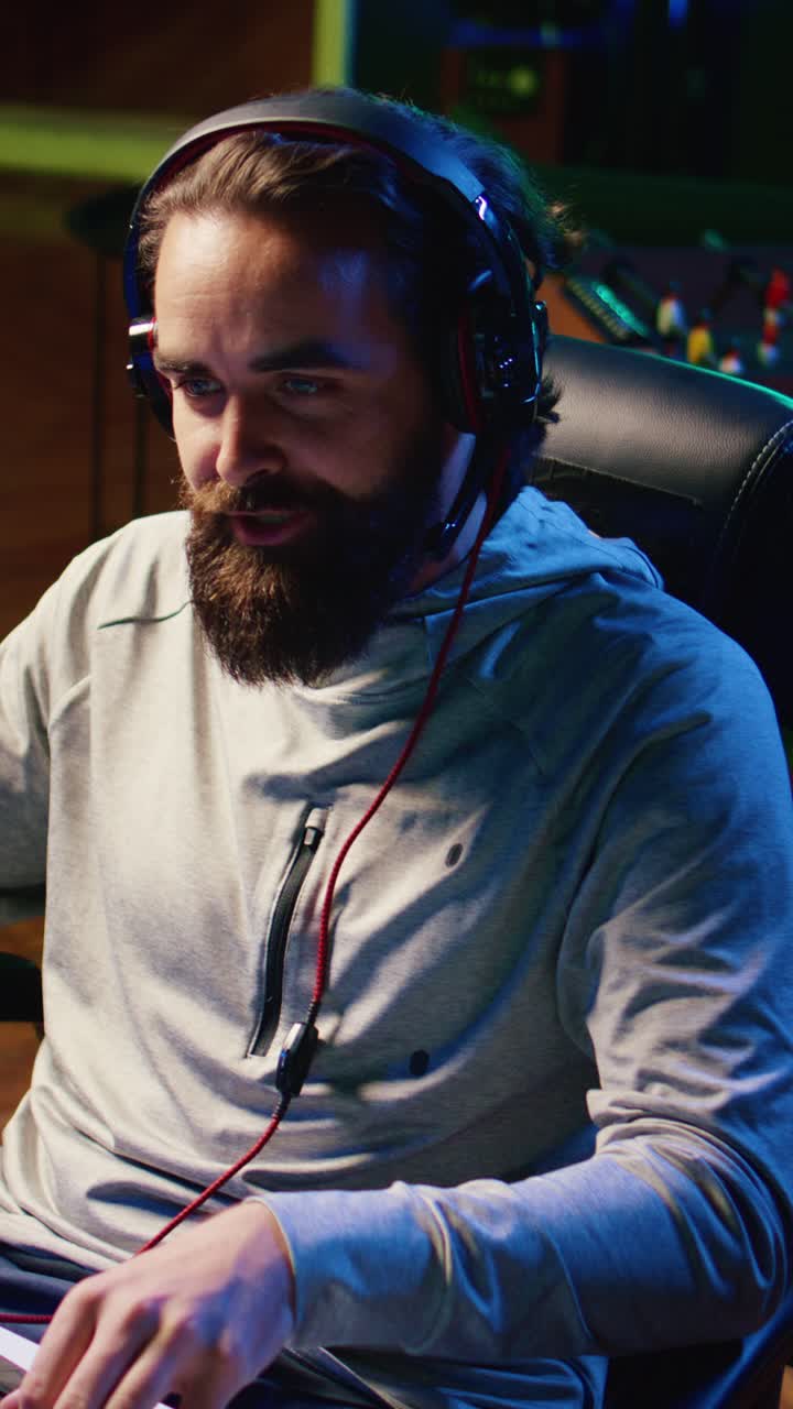Giocatore di videogiochi che realizza video verticali mentre parla con i compagni di squadra durante un torneo eSport competitivo, alla ricerca della strategia migliore
