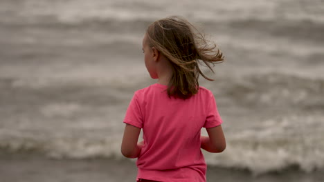 Kleines-Mädchen,-Das-Am-Meer-Steht-Und-Die-Wellen-Beobachtet