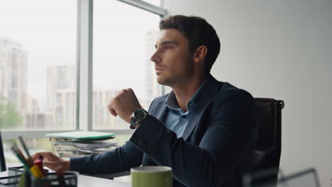 Thinking-man-typing-keyboard-in-glass-office-closeup.-Creative-designer-working