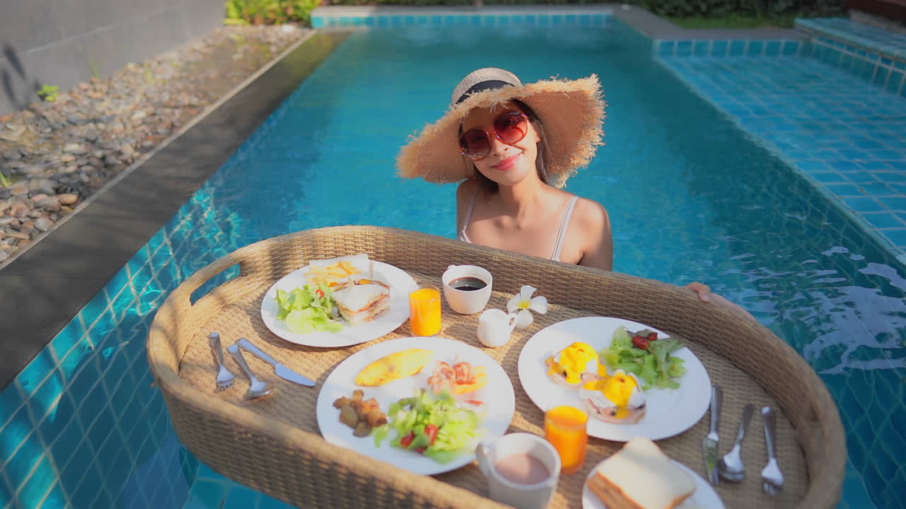 Woman enjoying breakfast in a swimming pool