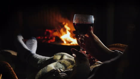 an evening alone by the fireplace with a glass of wine - escape from everything concept