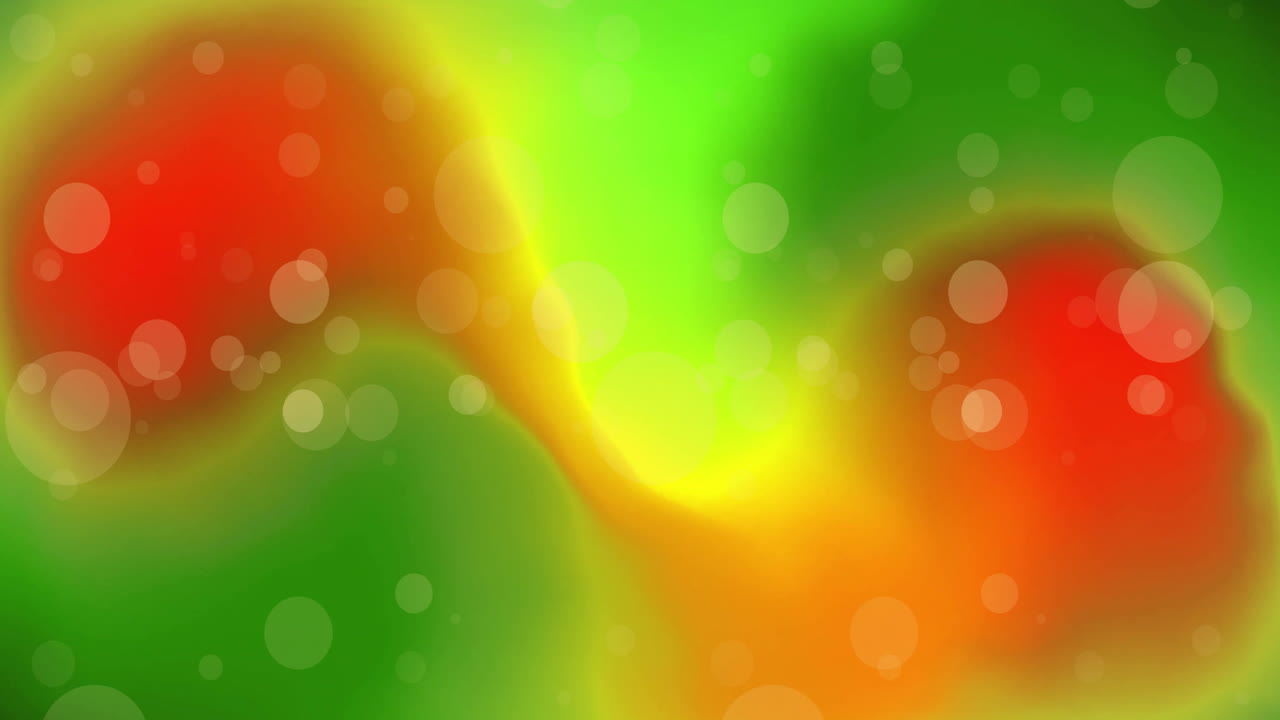 Animazione di sfere di luce bianca su luci verdi e arancioni.