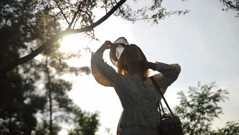 laughing joyfully, woman enjoying sunny day outdoors in park, feeling happy. happiness, nature, sunlight, relaxation, leisure, freedom